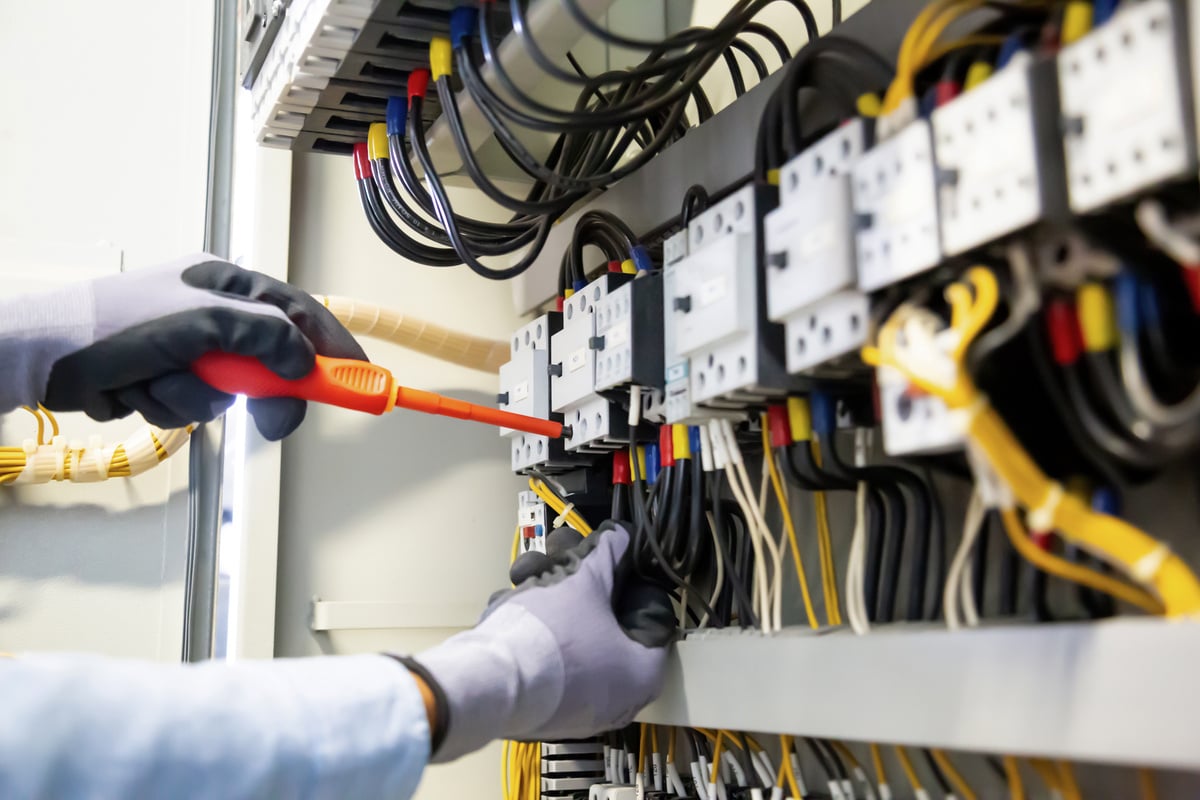 Electricians work to connect electric wires in the system, switchboard, electrical system in Control cabinet.